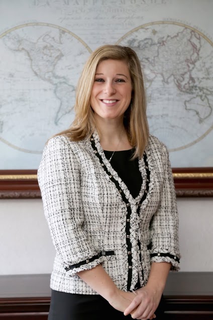 Attorney Jennifer Fay, standing before an antique world map